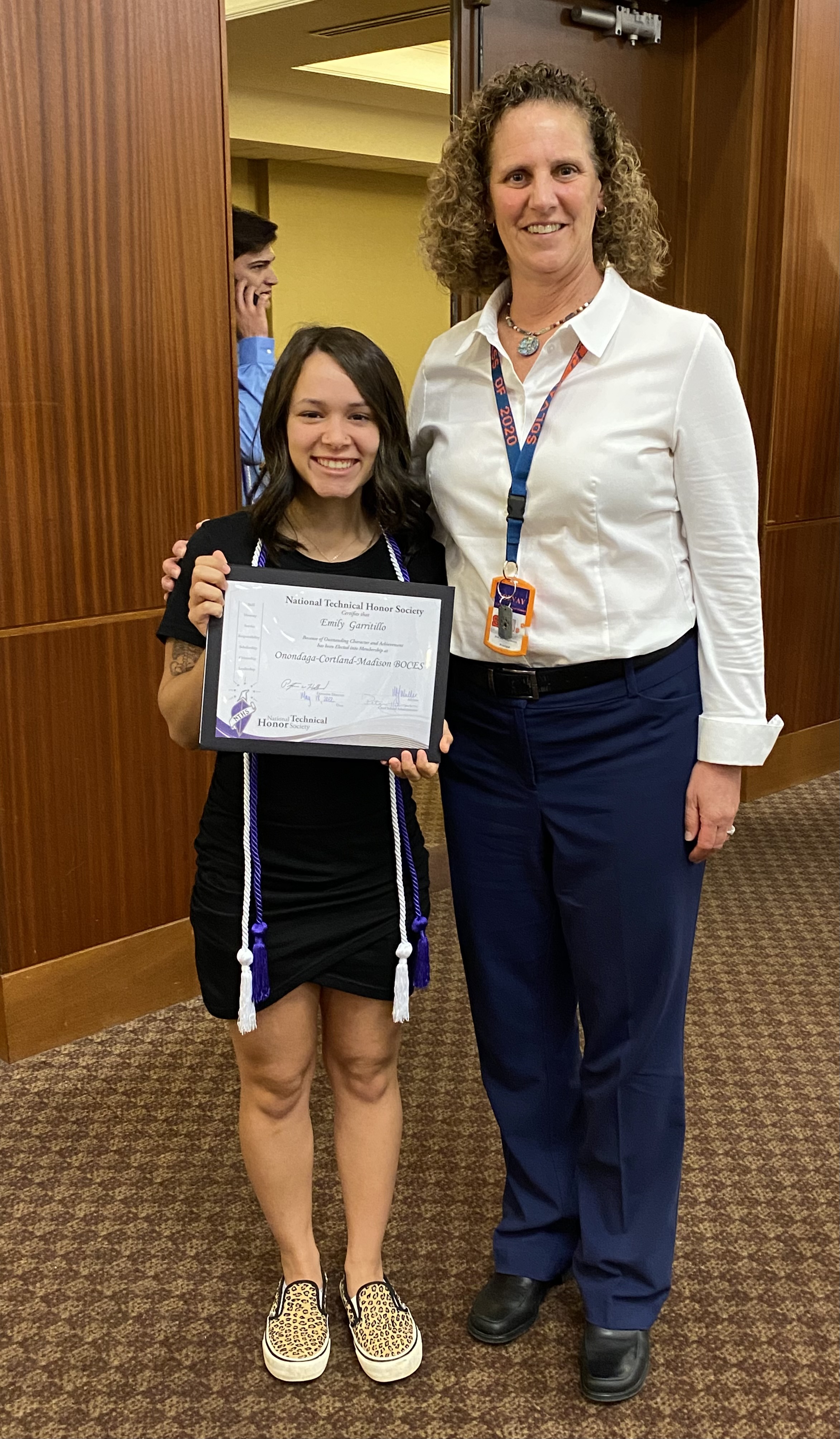 Student and principal pose with induction certificate