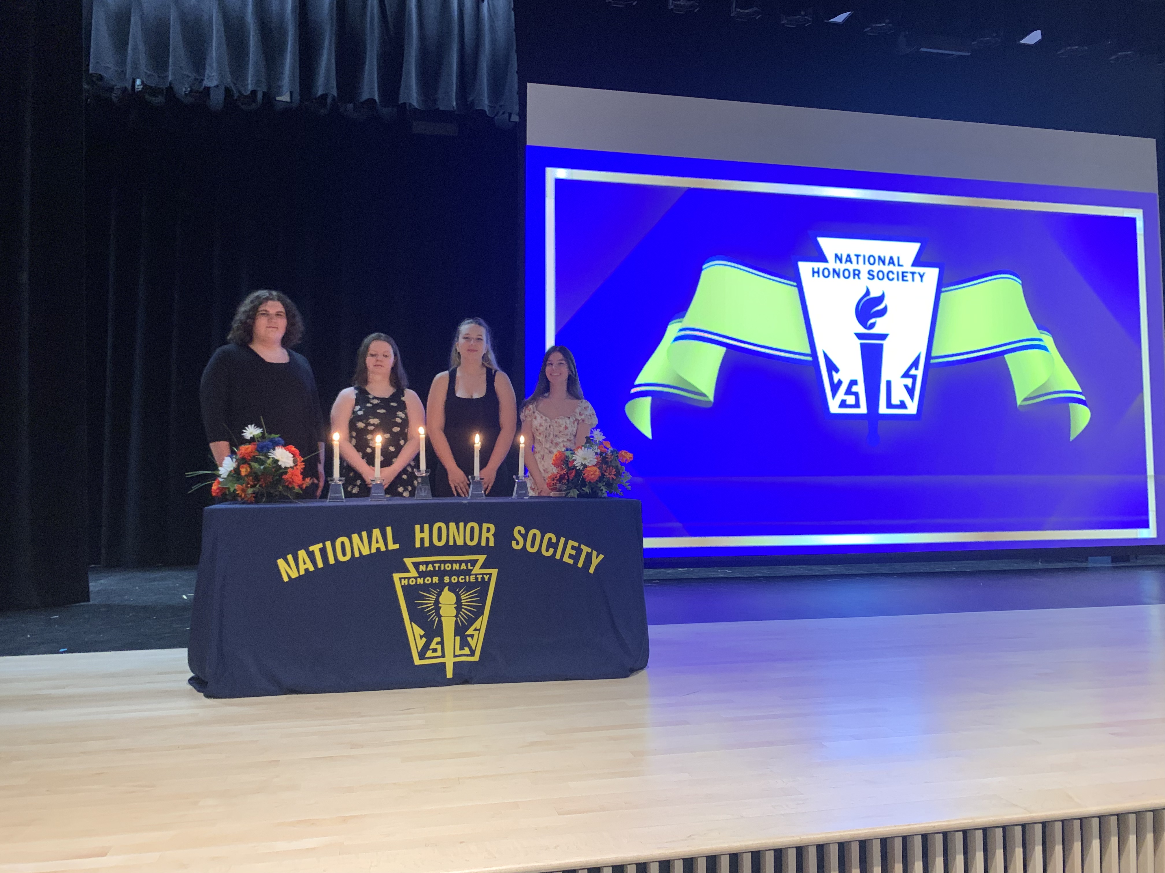 National Honor Society students pose for pictures on stage at Solvay High school