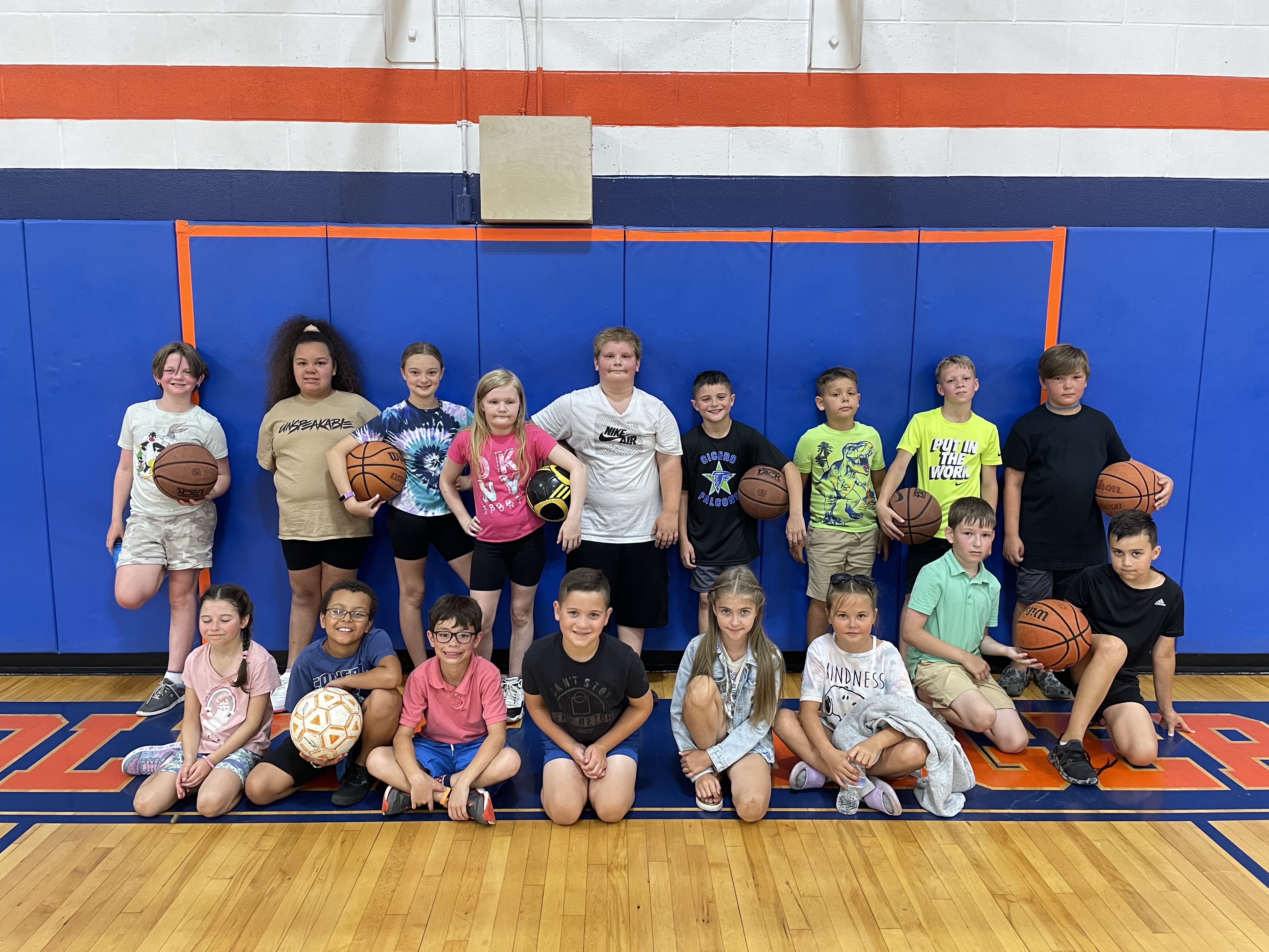 students playing basketball pose in the gym