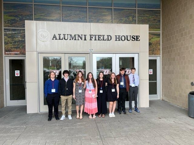 students pose at door of Suny Oneonta alumni field house