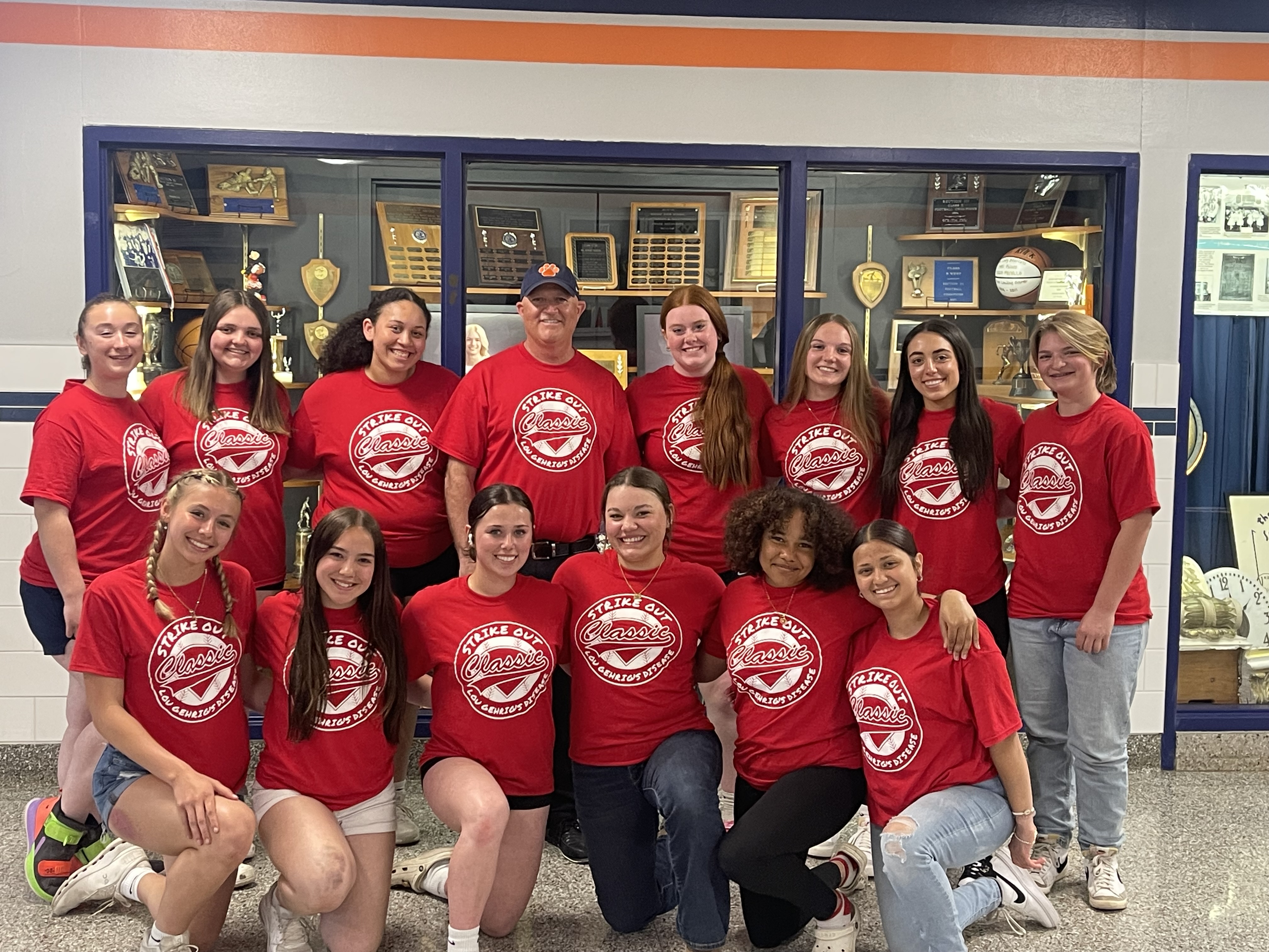 varsity softball team in red ALS shirts, posed