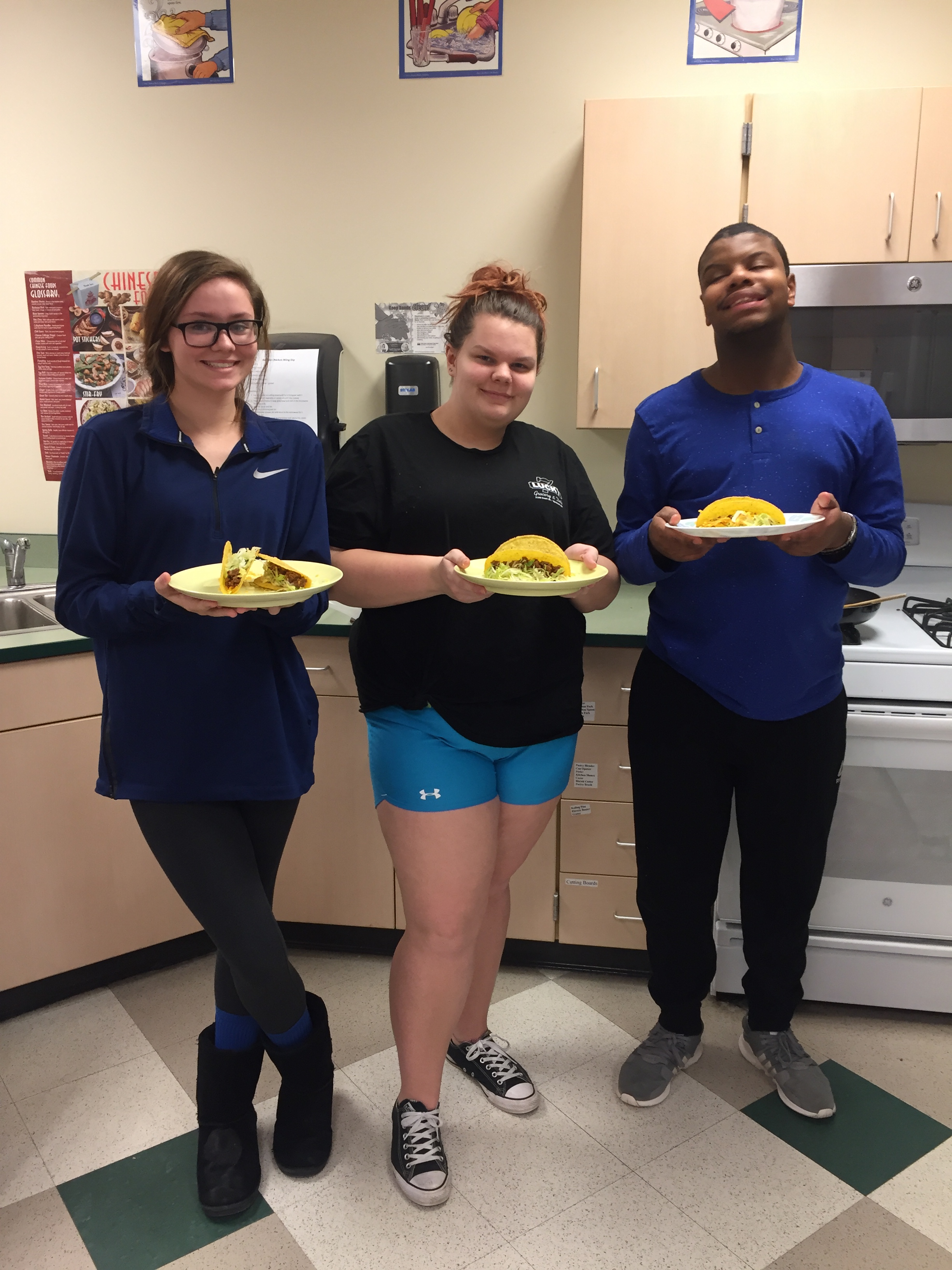 students pose with foods they made