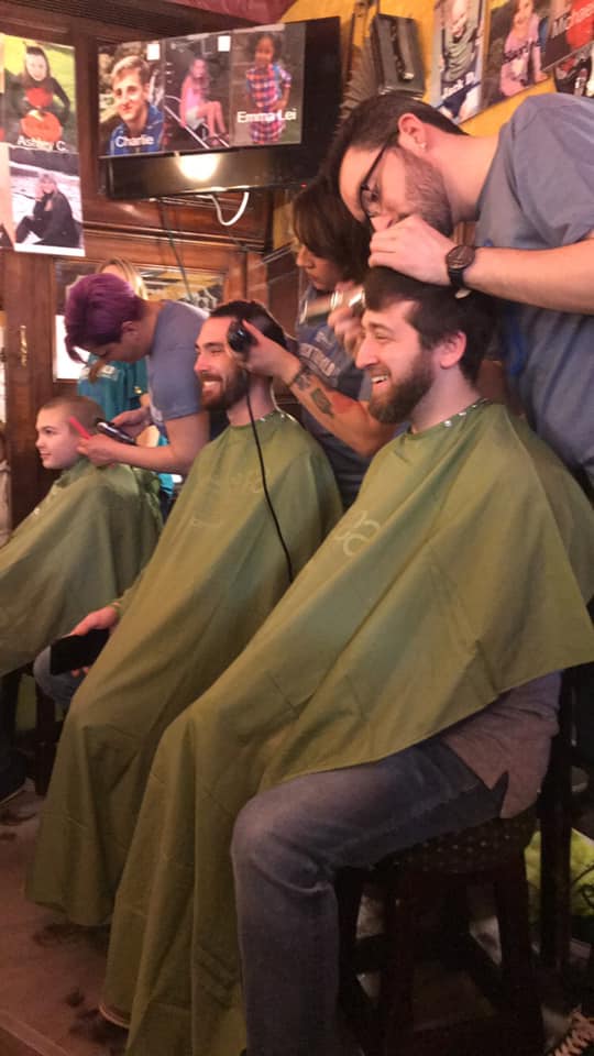 baldcats team members having their heads shaved